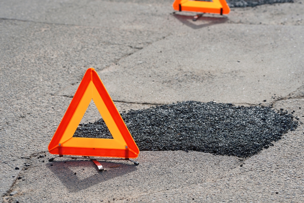 Fresh,Asphalt,Patch,Marked,By,Warning,Triangle,For,Safety.,Roadwork.