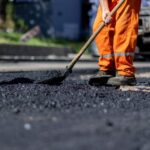 A,Construction,Worker,In,Bright,Orange,Attire,Is,Evenly,Distributing